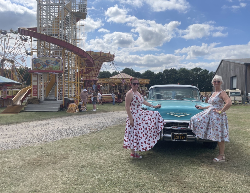 Two ladies in retro attire with classic car infront of the helter skelter